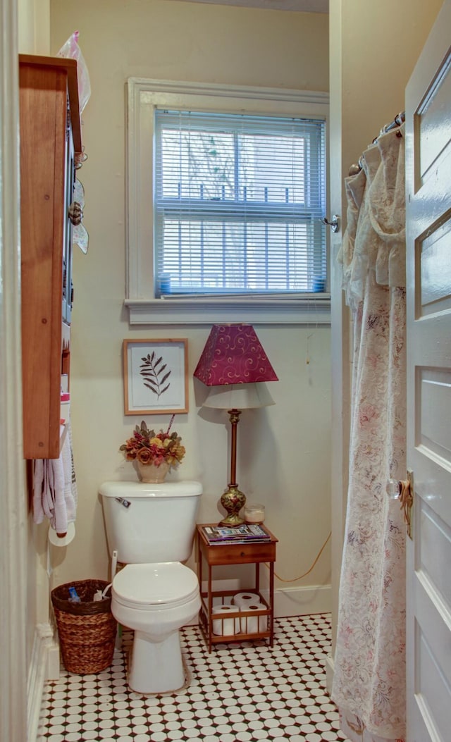 bathroom with toilet and curtained shower