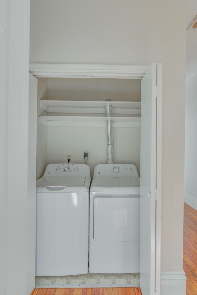 laundry room featuring washing machine and dryer, laundry area, and wood finished floors