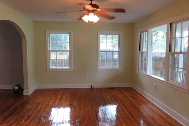 empty room with ceiling fan and dark hardwood / wood-style flooring