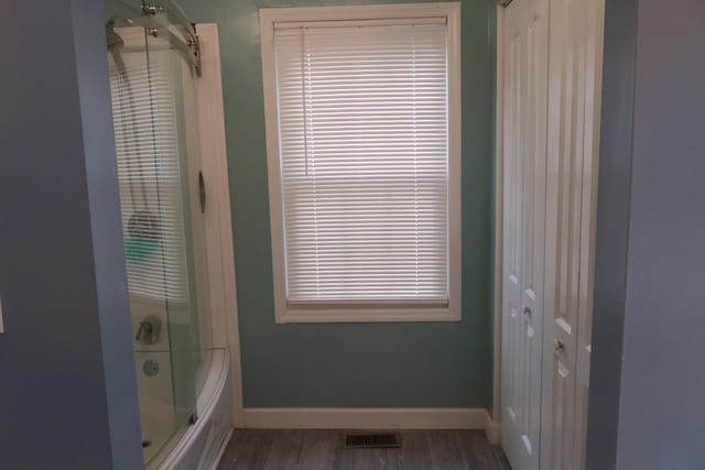 bathroom with hardwood / wood-style floors and an enclosed shower