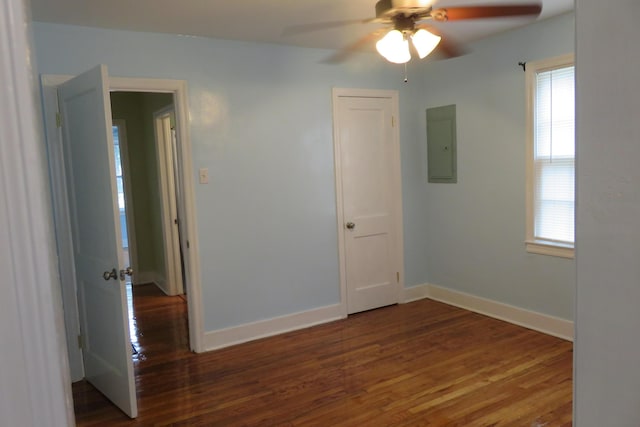 spare room featuring electric panel, ceiling fan, and dark wood-type flooring