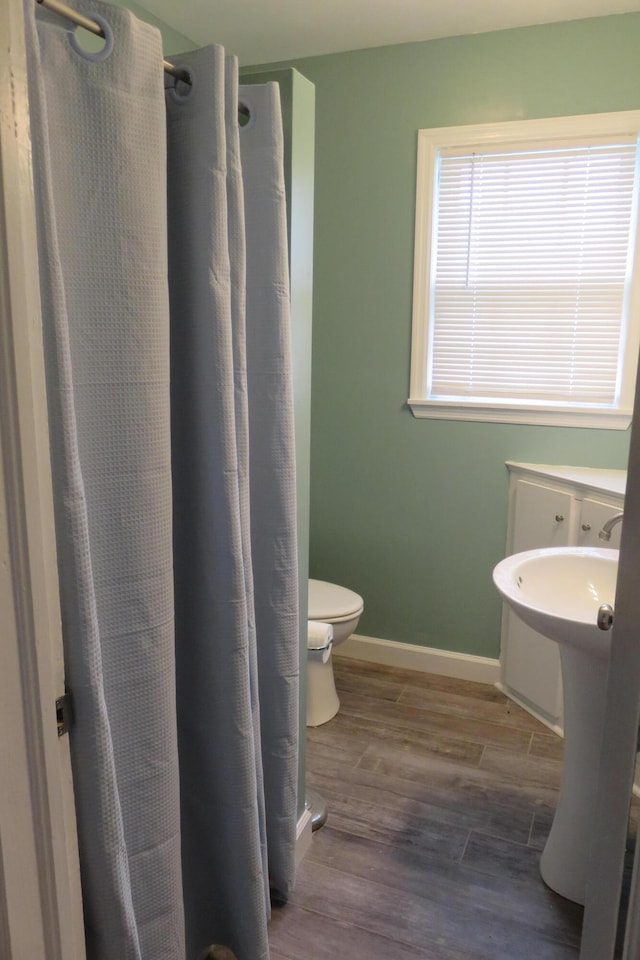 bathroom with hardwood / wood-style floors and toilet