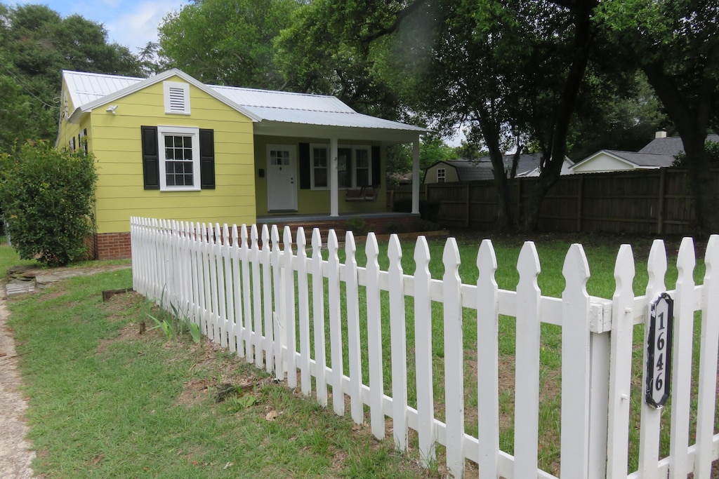 view of front of home with covered porch and a front yard