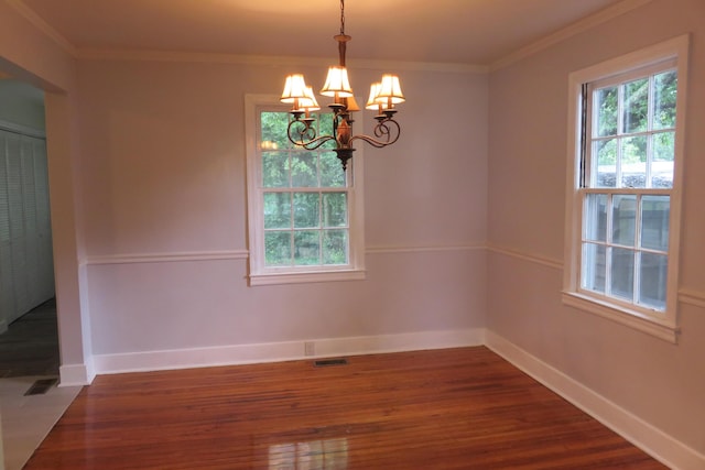 unfurnished room featuring crown molding, dark hardwood / wood-style floors, and a notable chandelier