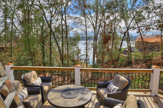 wooden terrace featuring a water view and an outdoor hangout area