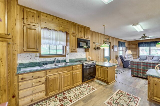 kitchen with sink, range with electric cooktop, hanging light fixtures, light hardwood / wood-style flooring, and ceiling fan