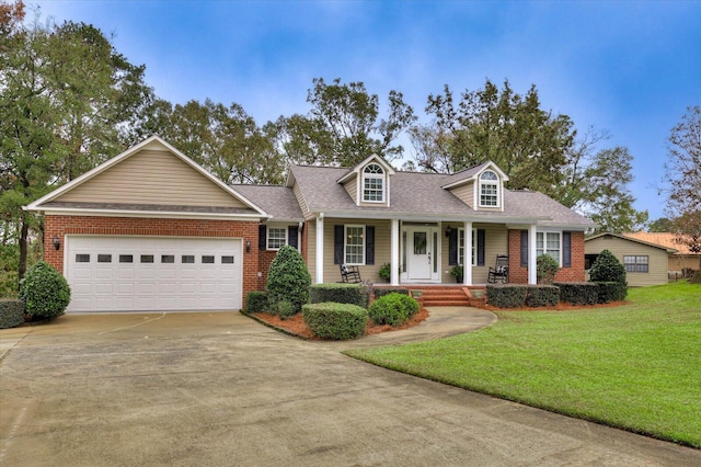 view of front of house with covered porch, a garage, and a front yard