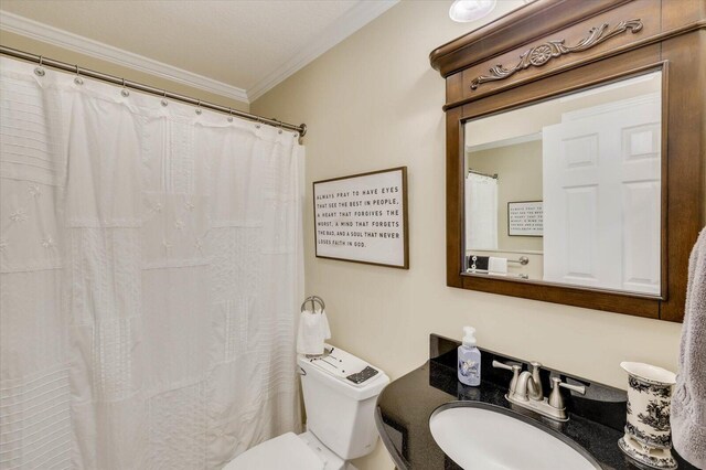 bathroom featuring toilet, ornamental molding, and sink