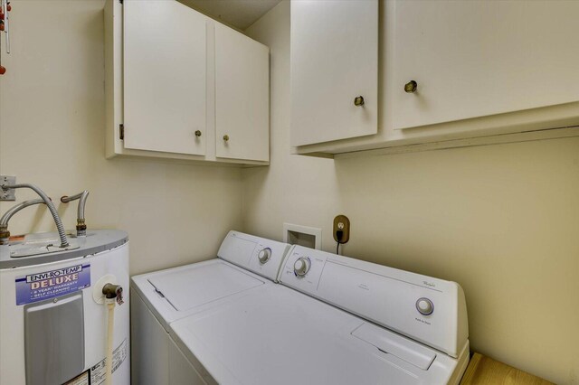 washroom with washing machine and dryer, electric water heater, and cabinets