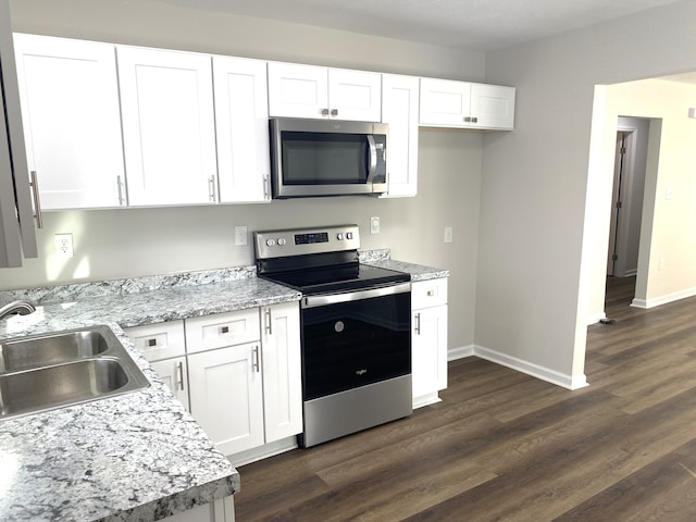 2113 Dyer St, Augusta, GA 30901 - kitchen with appliances with stainless steel finishes, a sink, white cabinets, and dark wood-style flooring