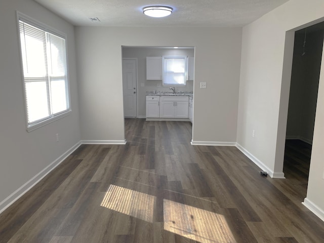2113 Dyer St, Augusta, GA 30901 - unfurnished dining area with dark wood finished floors, baseboards, a sink, and a textured ceiling