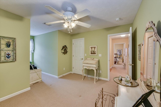 hallway with light colored carpet, visible vents, baseboards, and a textured ceiling