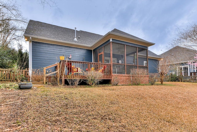 back of property with a yard, a sunroom, fence, and a deck