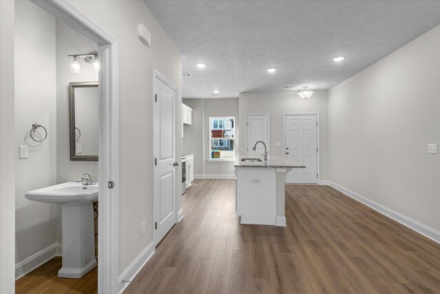 kitchen featuring white cabinets, a textured ceiling, dark hardwood / wood-style flooring, and sink