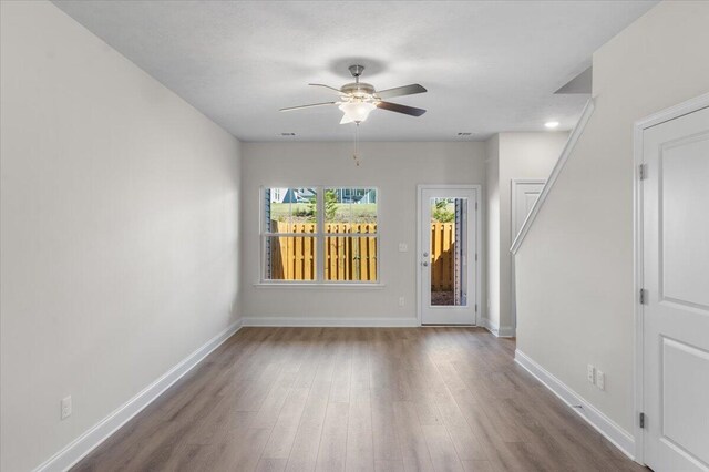 empty room with ceiling fan and dark hardwood / wood-style floors