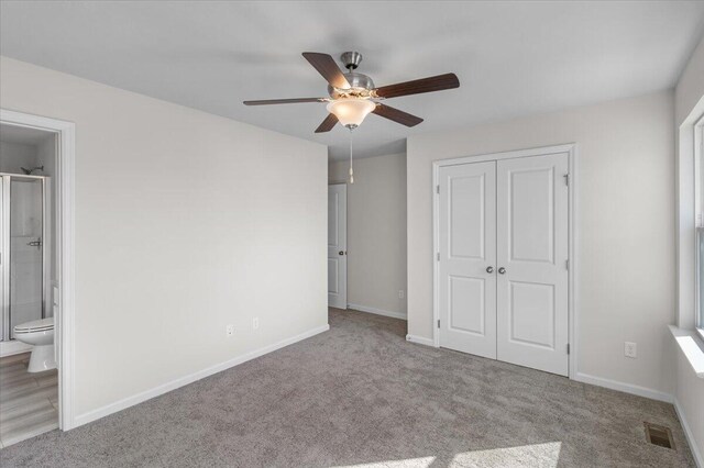 unfurnished bedroom featuring ensuite bathroom, a closet, ceiling fan, and light colored carpet