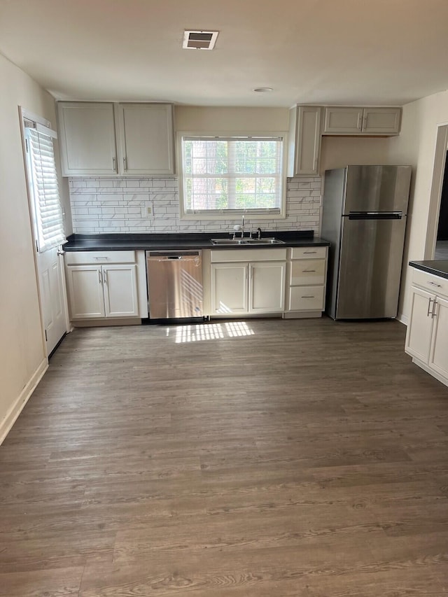 kitchen featuring decorative backsplash, hardwood / wood-style floors, stainless steel appliances, and sink