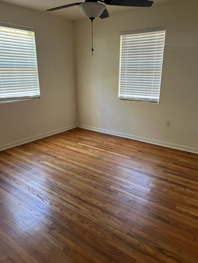 empty room with hardwood / wood-style flooring and ceiling fan