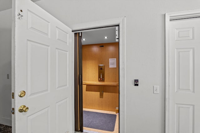corridor with elevator, recessed lighting, and baseboards