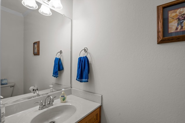 bathroom with crown molding, vanity, and toilet