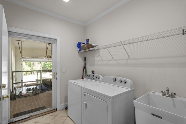 washroom with independent washer and dryer, crown molding, and light tile patterned floors