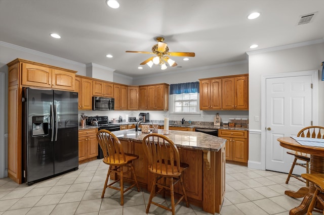 kitchen featuring black appliances, a kitchen breakfast bar, recessed lighting, dark stone counters, and ceiling fan