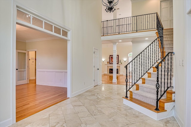 3954 Hammonds Fry, Evans, GA 30809 - entrance foyer featuring a lit fireplace, ornamental molding, stairway, marble finish flooring, and ornate columns