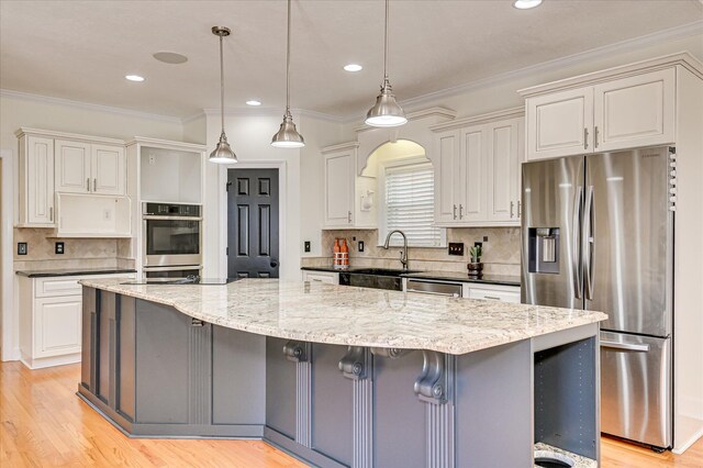 3954 Hammonds Fry, Evans, GA 30809 - kitchen with appliances with stainless steel finishes, a spacious island, tasteful backsplash, white cabinets, and light wood finished floors