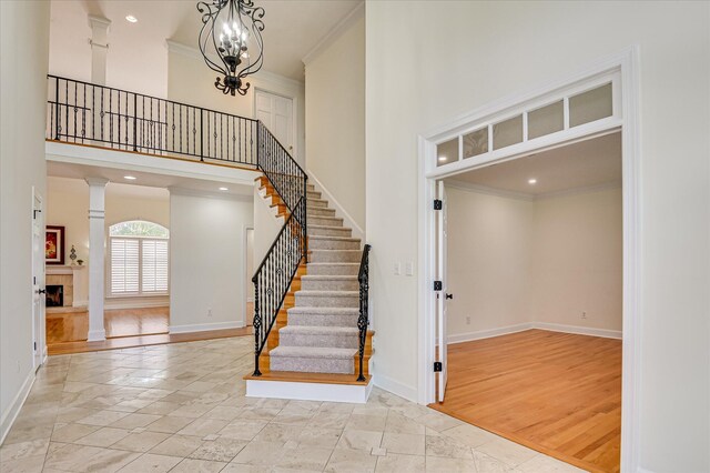 3954 Hammonds Fry, Evans, GA 30809 - stairway featuring a towering ceiling, crown molding, decorative columns, recessed lighting, and a tiled fireplace