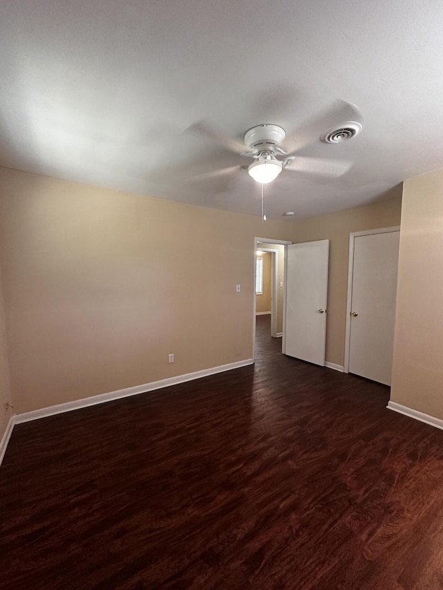 spare room with ceiling fan and dark wood-type flooring