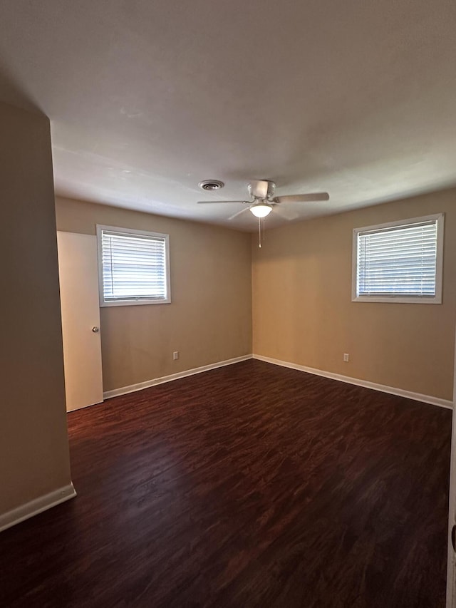 spare room featuring ceiling fan and dark wood-type flooring