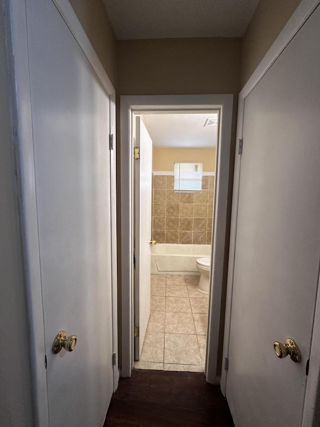 hall with tile patterned floors