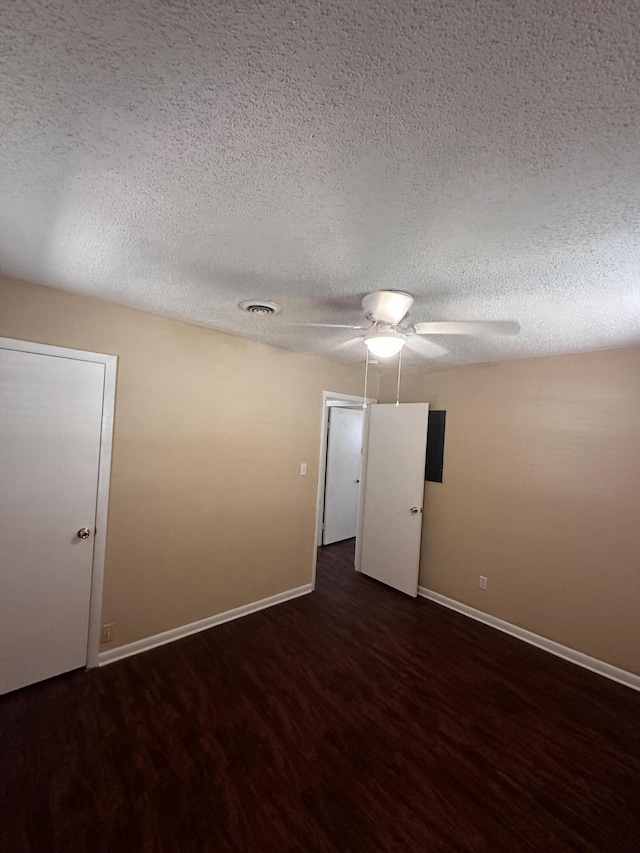 unfurnished room featuring dark wood-type flooring and a textured ceiling