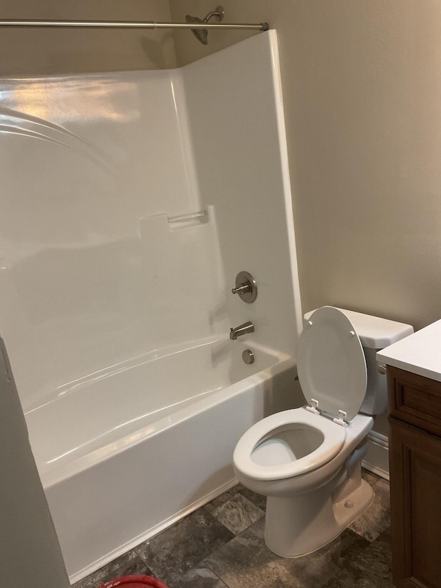 bathroom featuring toilet, vanity, and  shower combination