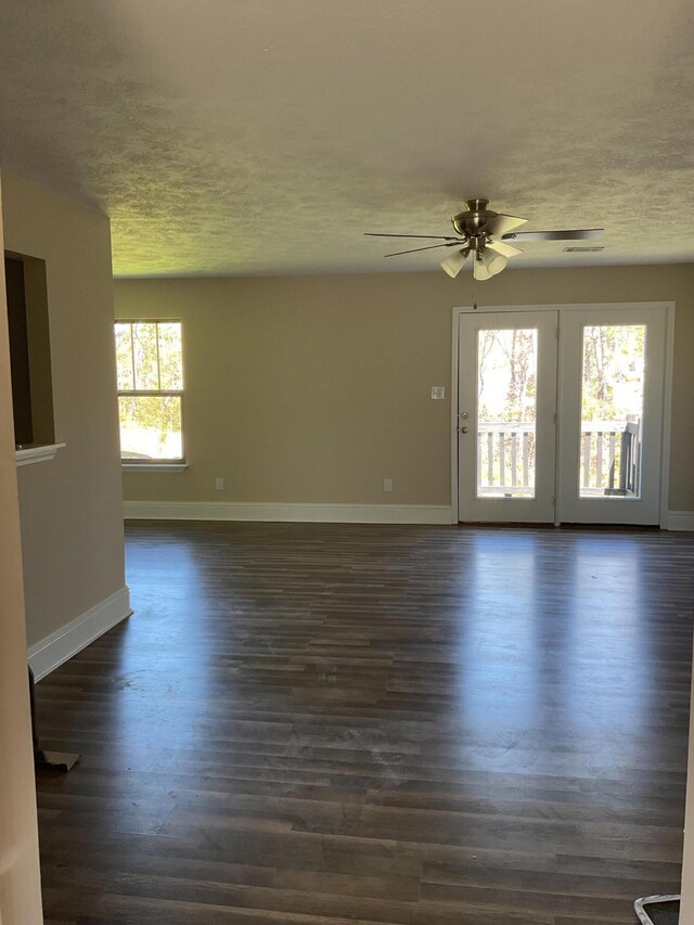 spare room featuring ceiling fan, baseboards, a textured ceiling, and dark wood-style floors