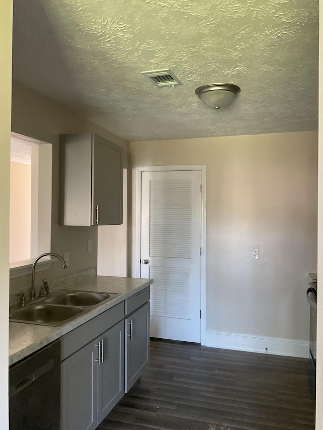 kitchen featuring visible vents, baseboards, dark wood finished floors, dishwasher, and a sink