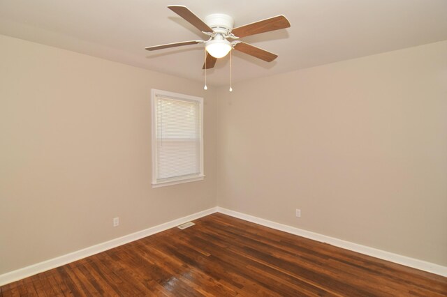spare room with visible vents, a ceiling fan, baseboards, and dark wood-style floors
