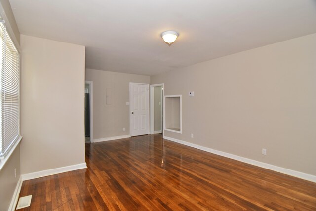 spare room featuring baseboards and wood-type flooring