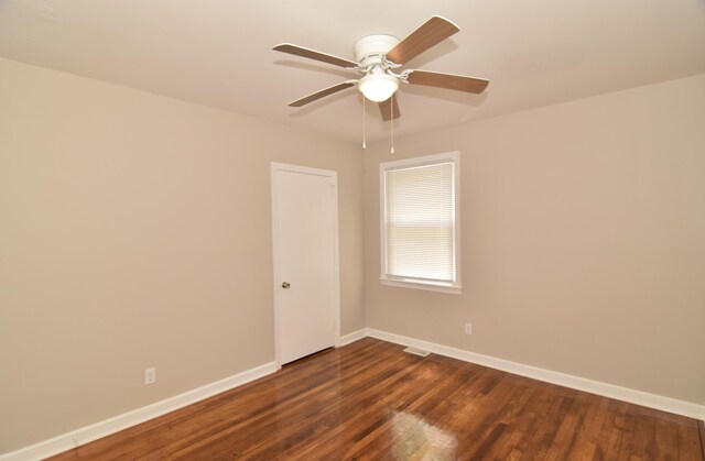 unfurnished room with visible vents, a ceiling fan, baseboards, and dark wood-style flooring