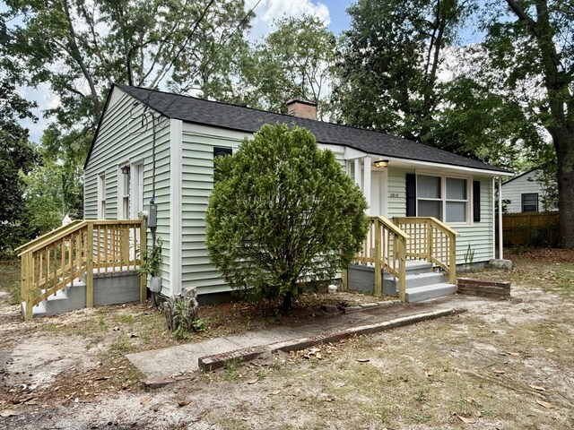 view of front of house with fence and a chimney
