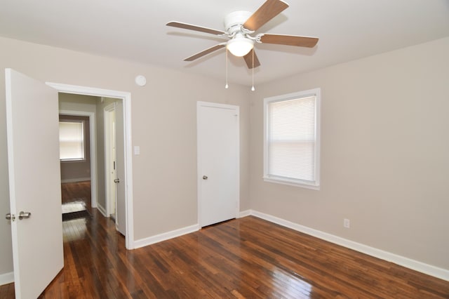 unfurnished bedroom with baseboards, a closet, and hardwood / wood-style flooring