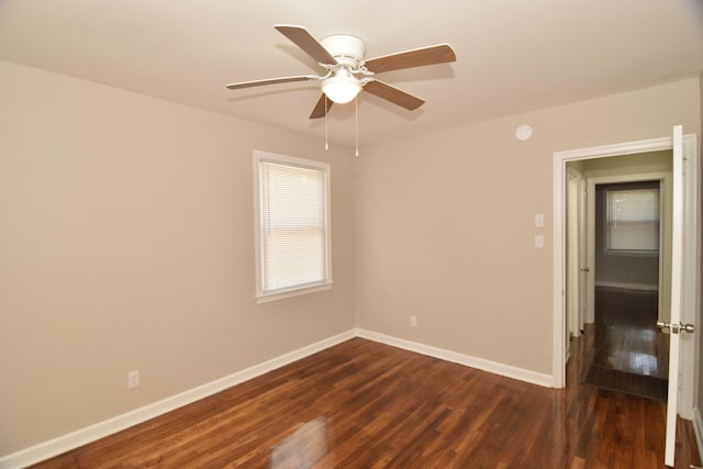 empty room featuring ceiling fan, baseboards, and dark wood-style flooring