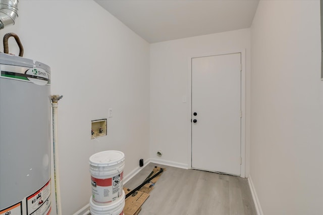 clothes washing area featuring laundry area, baseboards, hookup for a washing machine, electric dryer hookup, and water heater