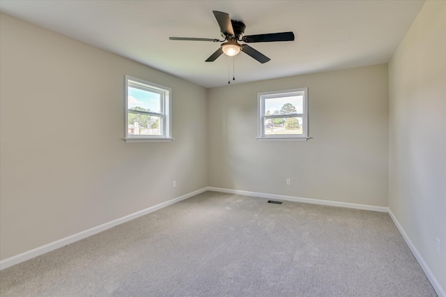 spare room featuring baseboards, carpet, and a healthy amount of sunlight