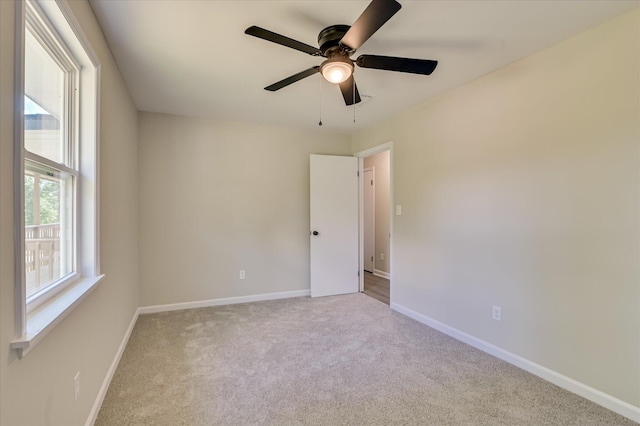 unfurnished room with carpet floors, baseboards, and a ceiling fan
