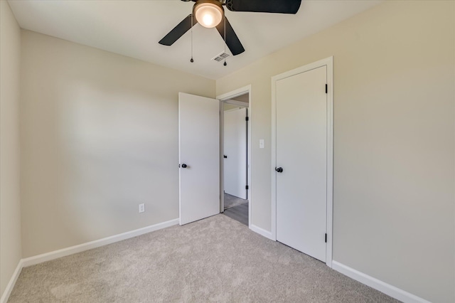 unfurnished bedroom with baseboards, visible vents, ceiling fan, and carpet