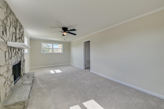 unfurnished living room with crown molding, a ceiling fan, a stone fireplace, and light carpet
