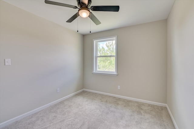 spare room with baseboards, carpet flooring, and a ceiling fan