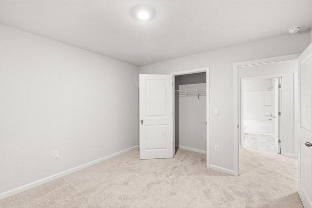 unfurnished bedroom with light colored carpet and a closet