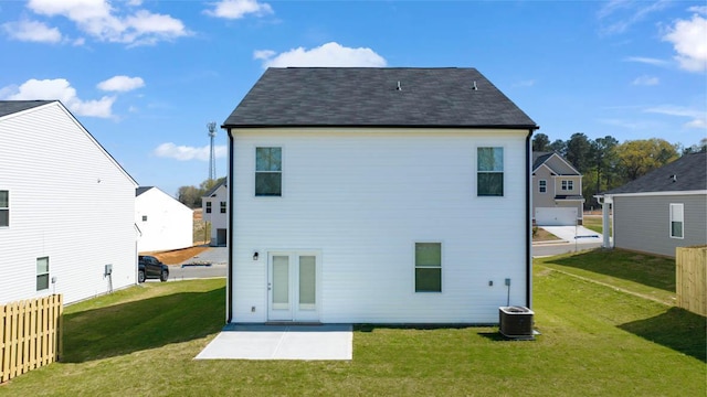 back of house with central air condition unit, a patio area, and a lawn